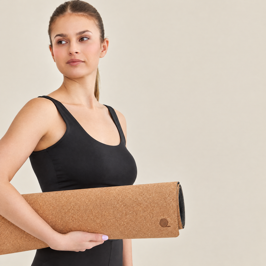 Woman holding the rolled Essential cork yoga mat